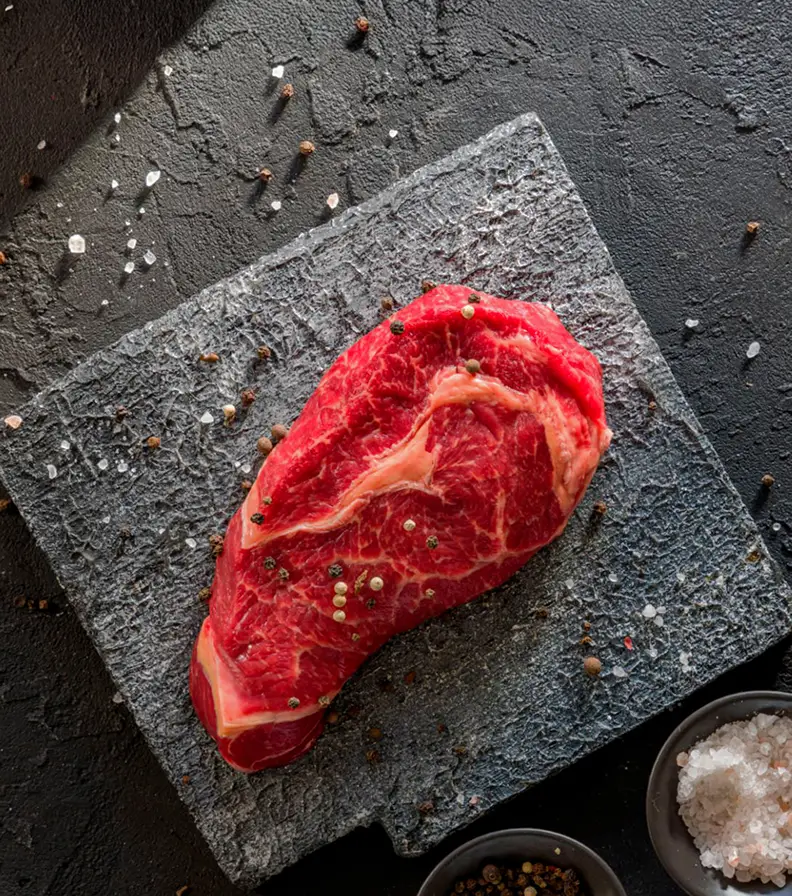 Corte premium de carne fresca sobre tábua de pedra, ideal para gastronomia de excelência e restauração Horeca.